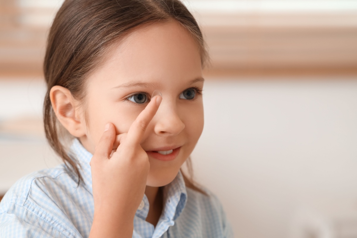 Young girl putting in a contact lens.
